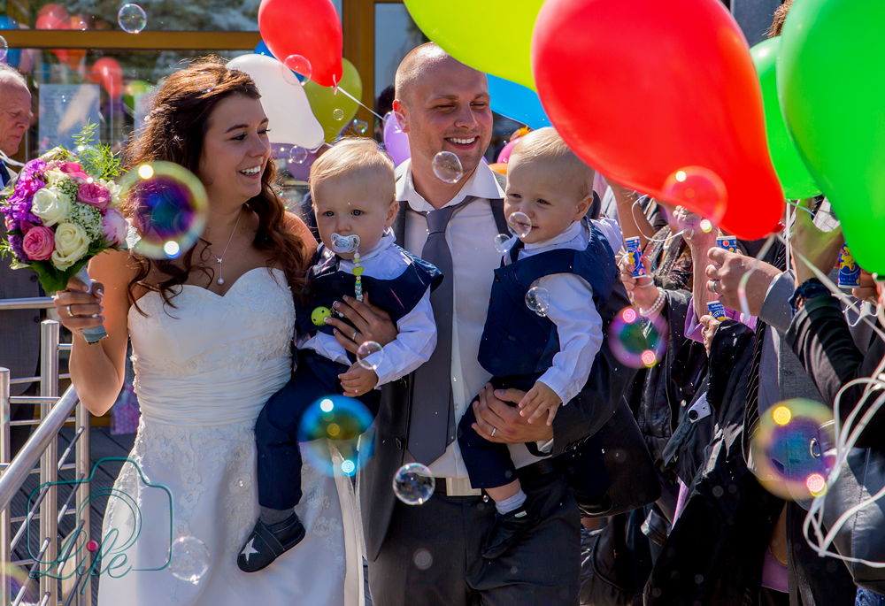 Foto eines Hochzeitspaares: Paar mit Kindern, Luftballons, Gäste